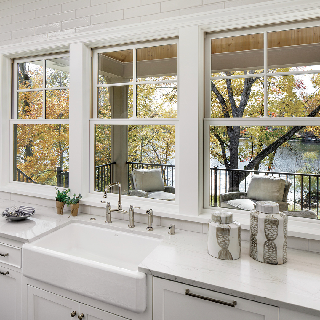A kitchen with a sink and a lot of windows