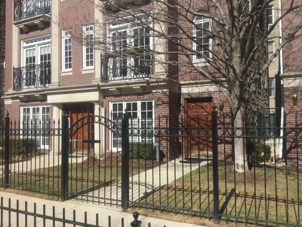 A brick building with a wrought iron fence around it