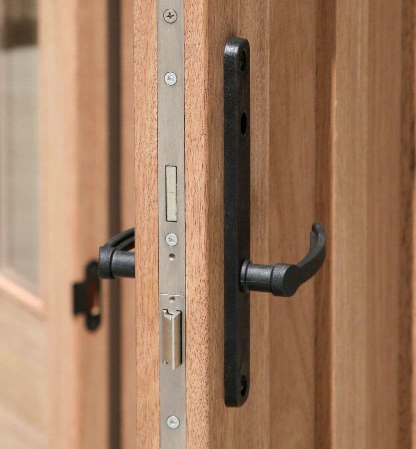 A close up of a door handle on a wooden door.