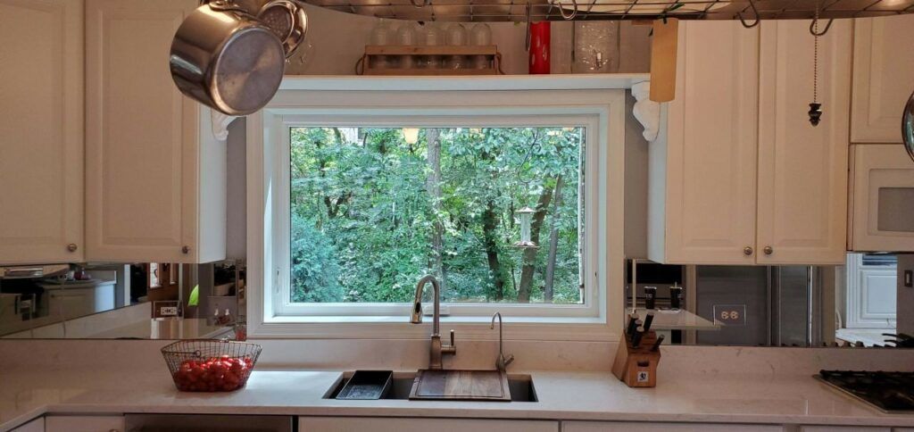 A kitchen with a sink and pots hanging from the ceiling