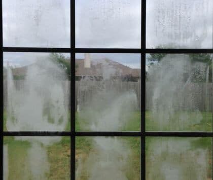 A close up of a window with a lot of condensation on it.