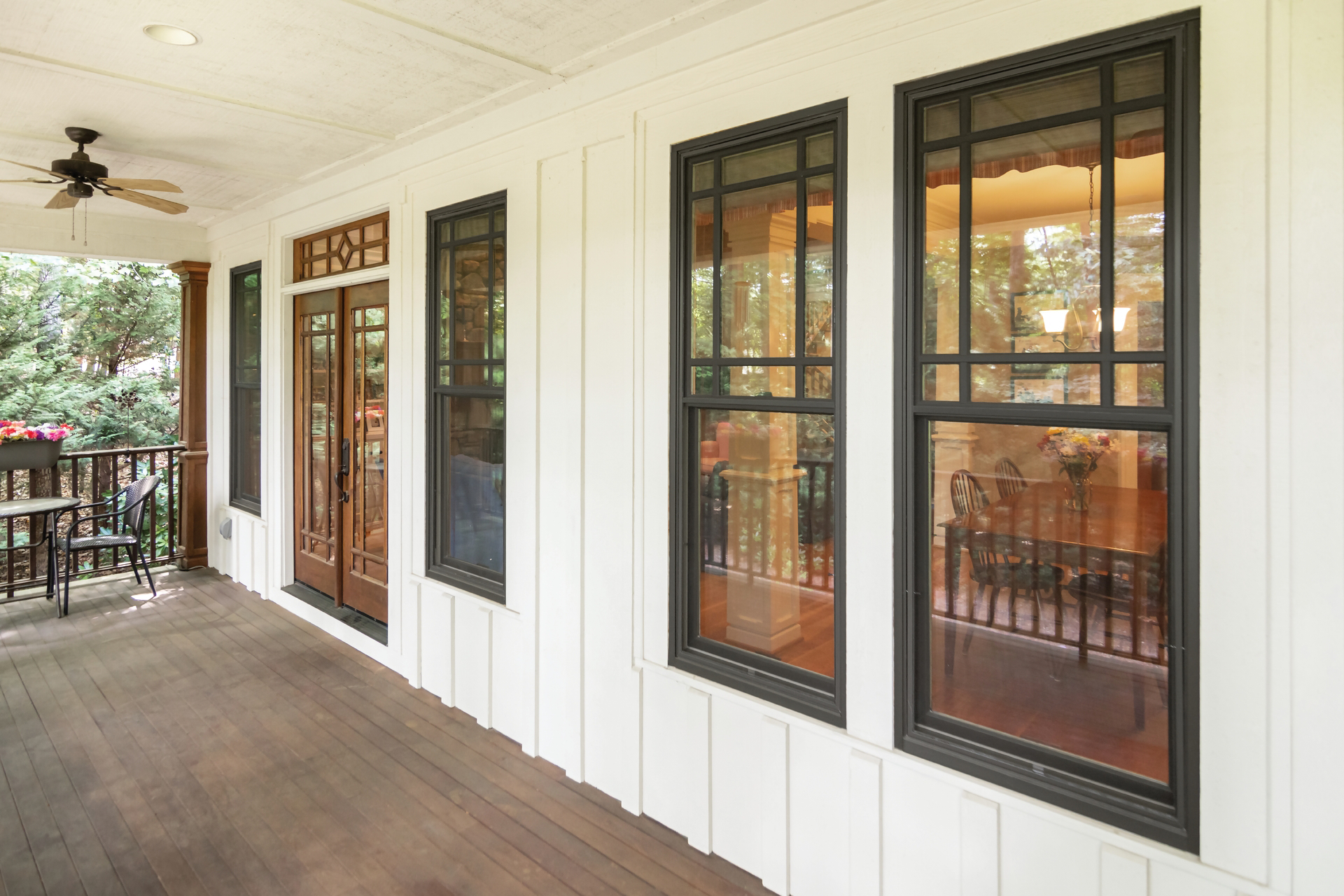 A porch with a lot of windows and a ceiling fan