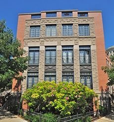 A large brick building with lots of windows and trees in front of it.