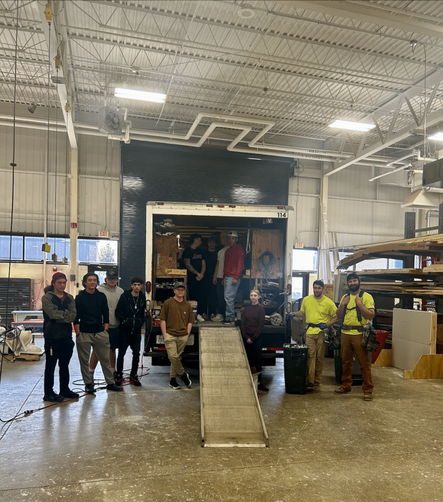 A group of students standing in front of a truck