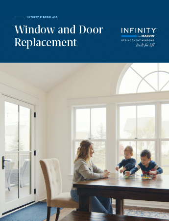 A woman and a child are sitting at a table in front of a window and door replacement brochure.