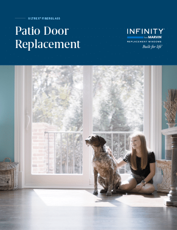 A woman is sitting on the floor with a dog in front of a patio door.