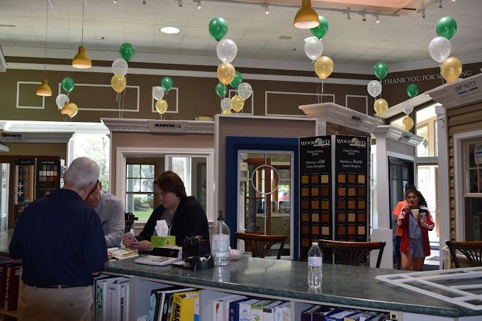 Two men are sitting at a table looking at a laptop computer.