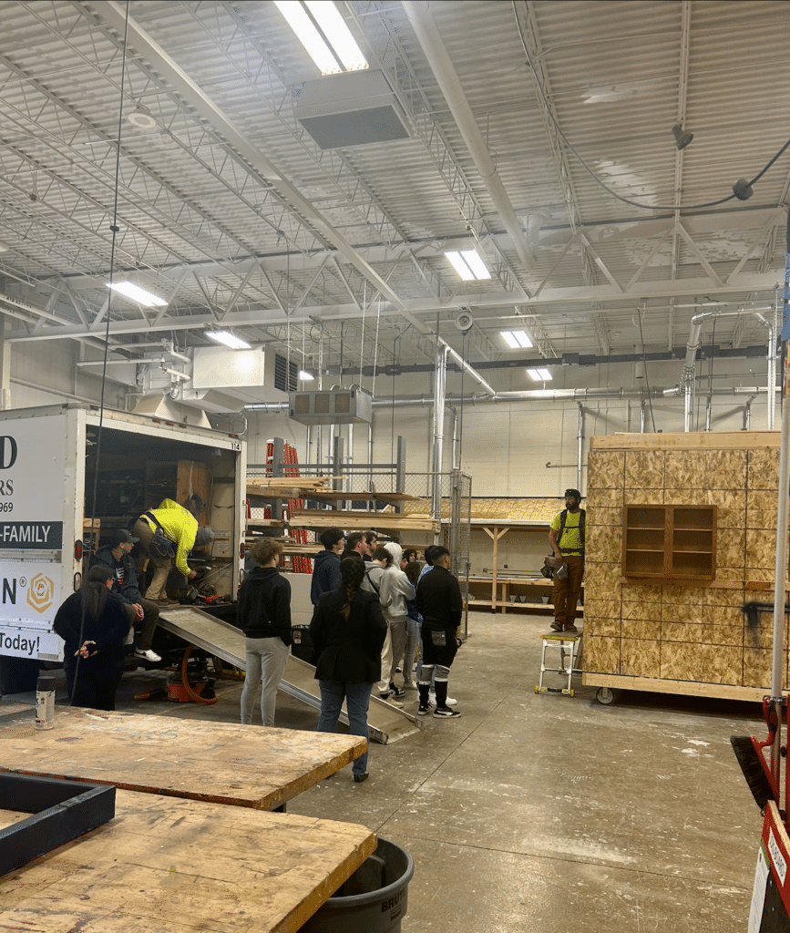 A group of people are standing in a large warehouse.