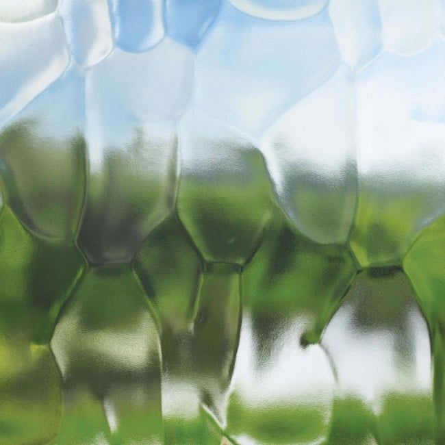 A close up of a glass bottle with a green background.