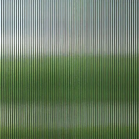 A close up of a glass wall with a green field in the background.