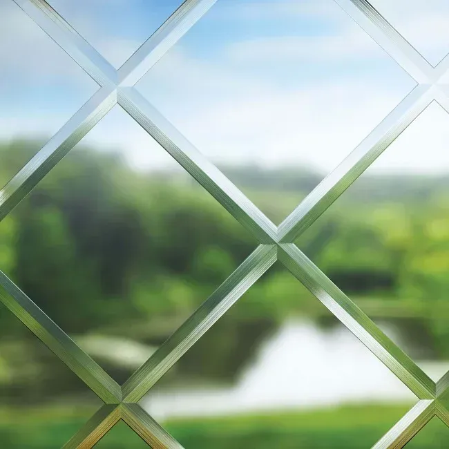 A close up of a diamond cut glass window with a blurred background.