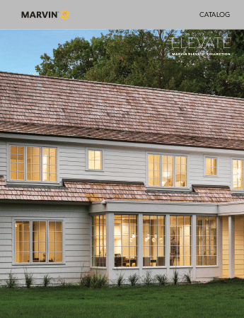 A white house with a brown roof and lots of windows