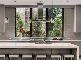 A kitchen with a large island , stove , sink , and window.