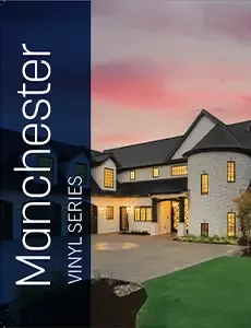 A large white house with a black roof is sitting on top of a lush green lawn.