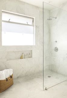 A bathroom with a walk in shower and a window.