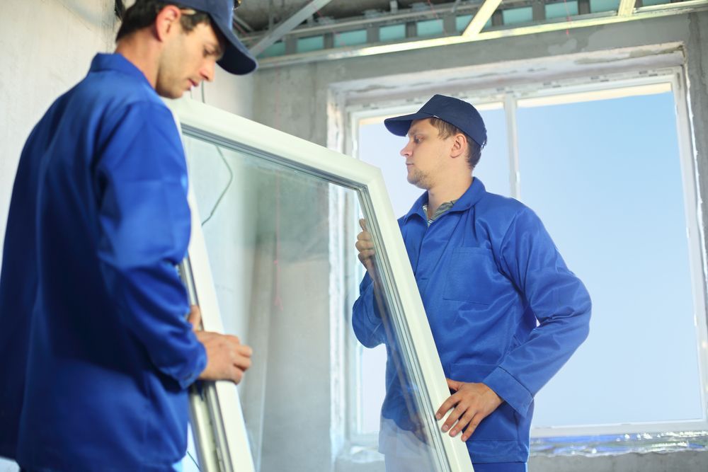 Two workers are replacing a window.