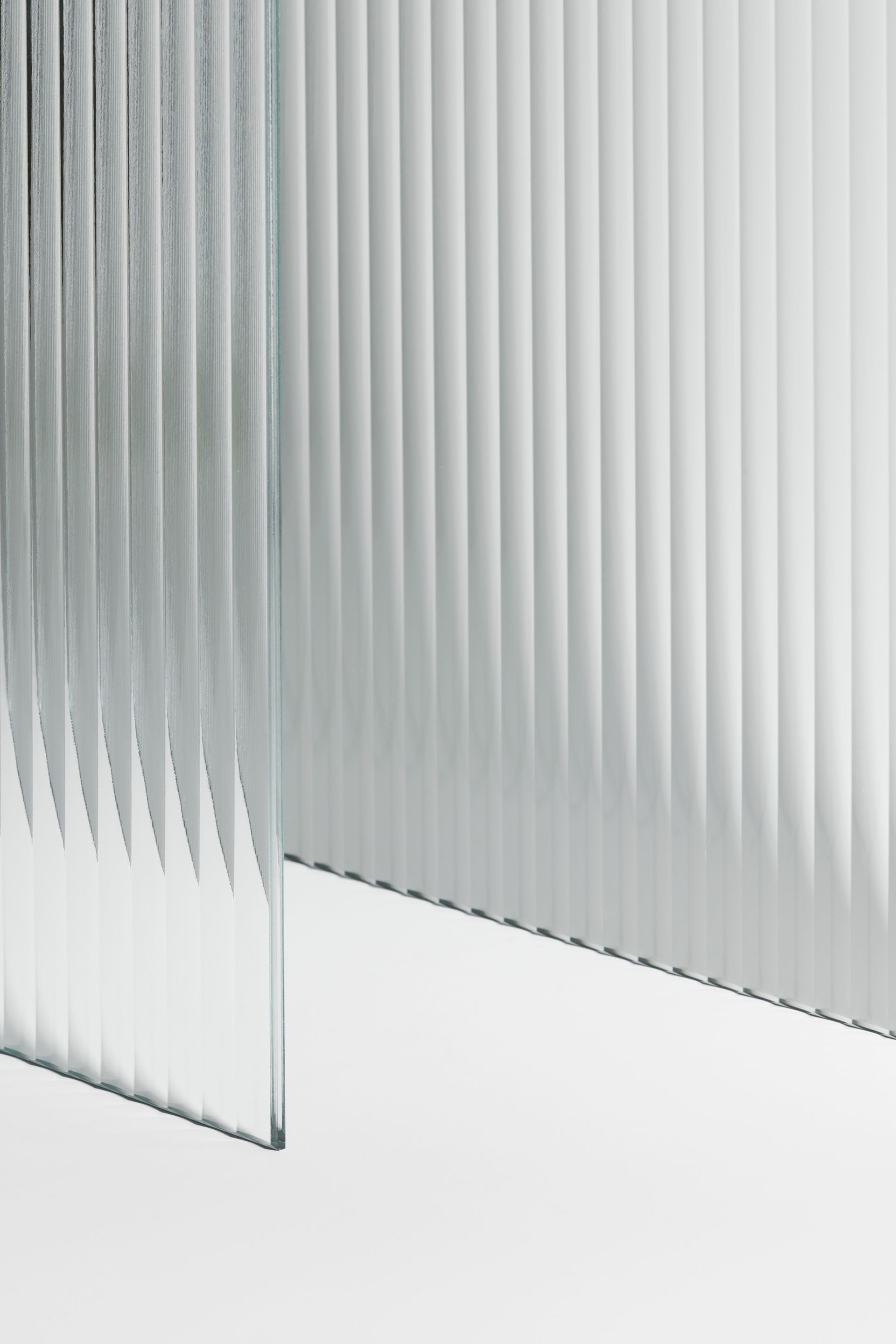 A close up of a piece of glass with a striped pattern on a white surface.