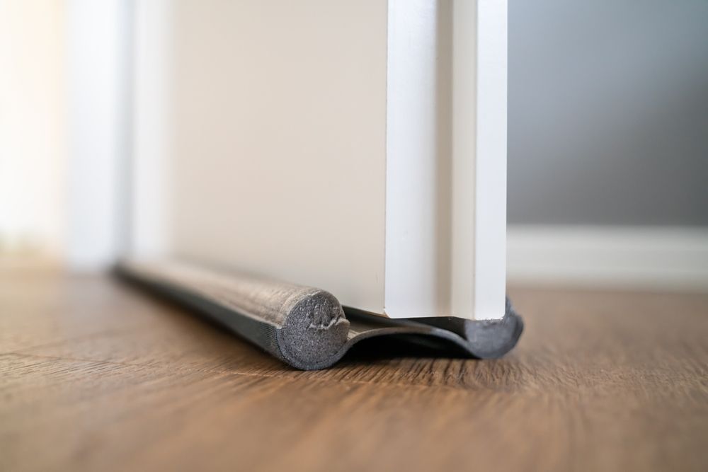 A door stopper is sitting on a wooden floor next to a door.