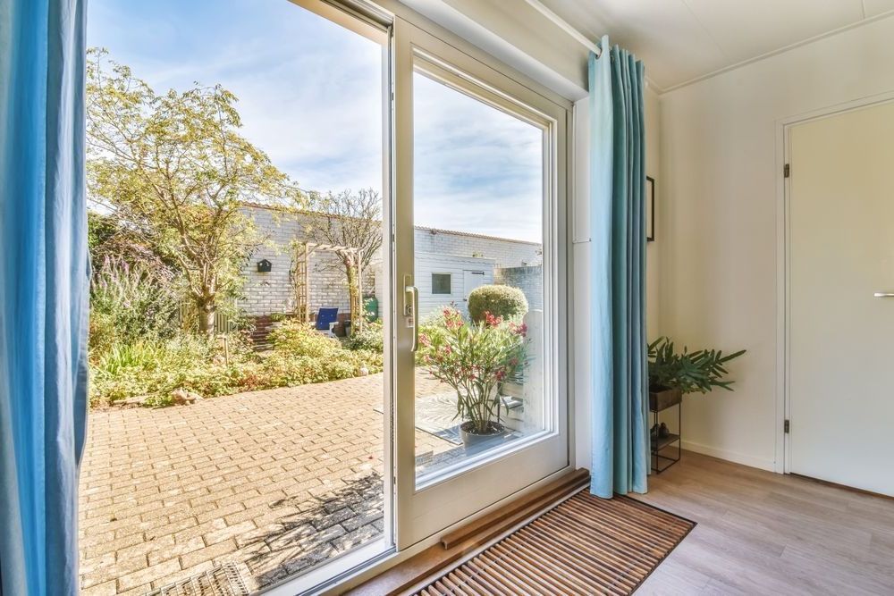 A room with a sliding glass door leading to a garden.