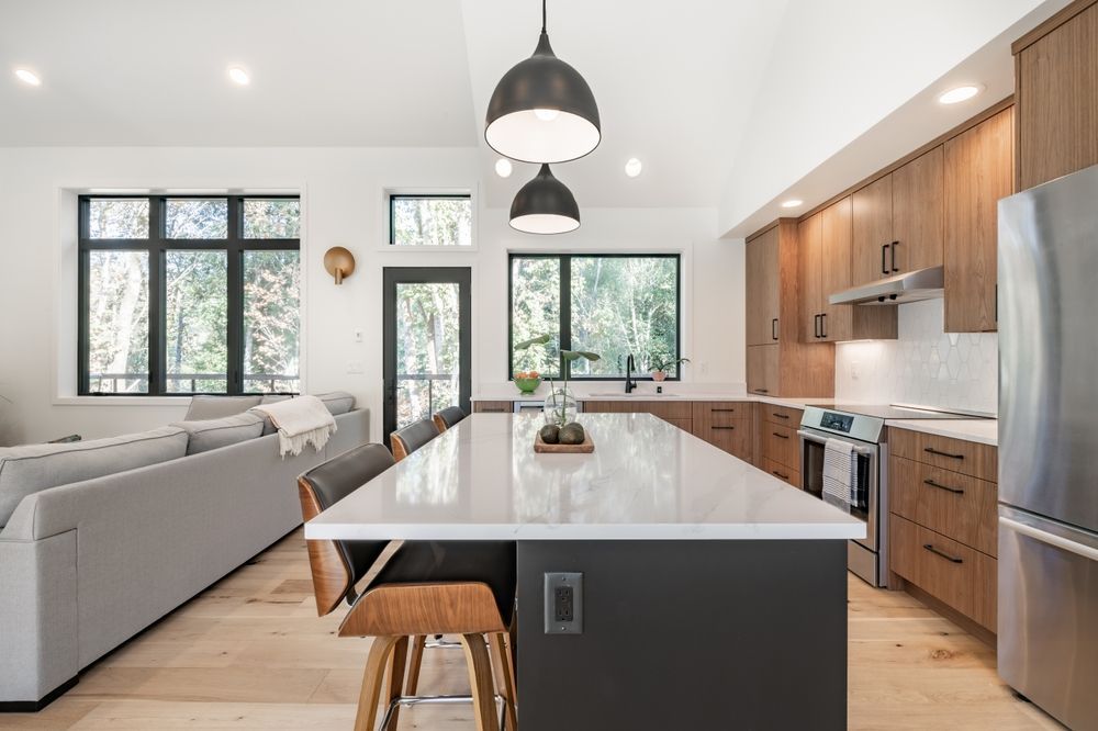 A kitchen with stainless steel appliances and a large island in the middle.