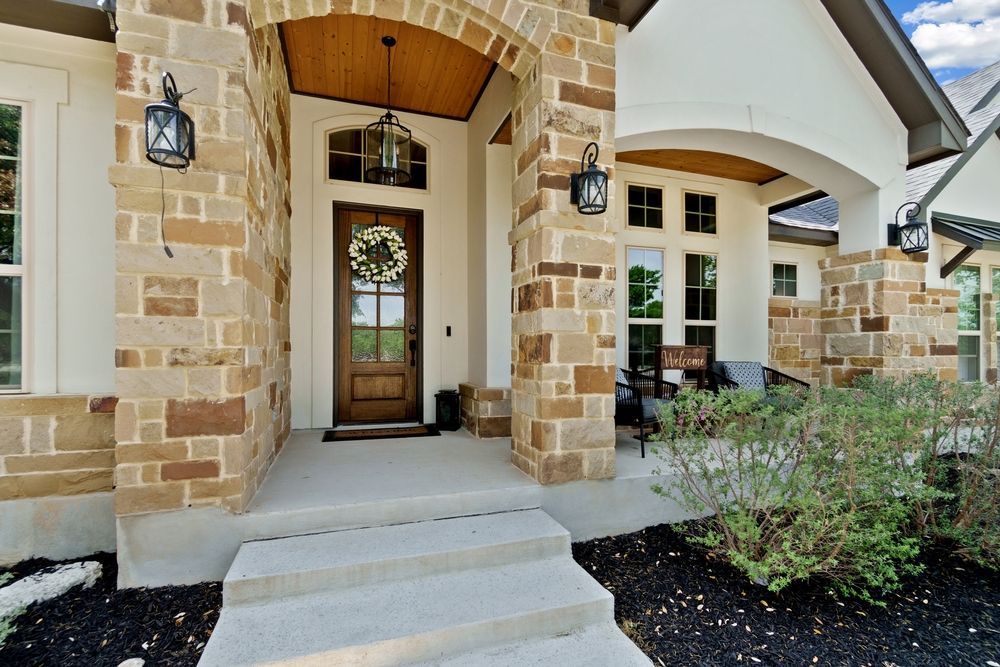 The front porch of a house with a wreath on the door.