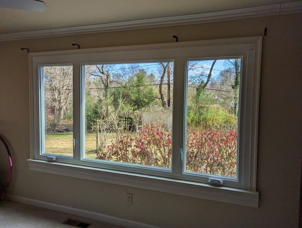 A large window in a room with a view of a garden.