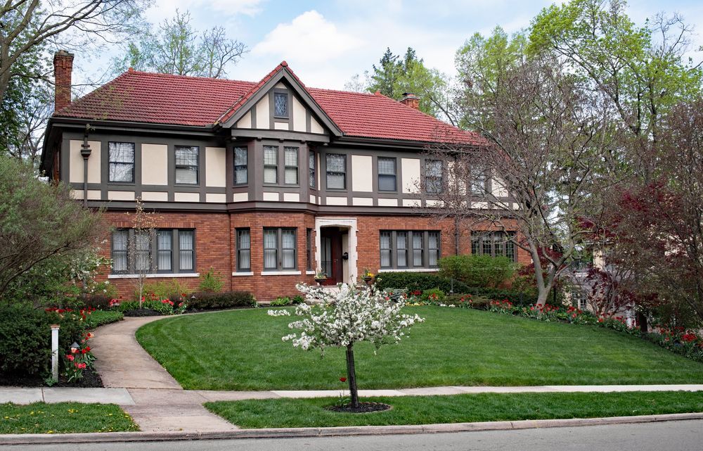 A white house with a black roof and sliding glass doors.