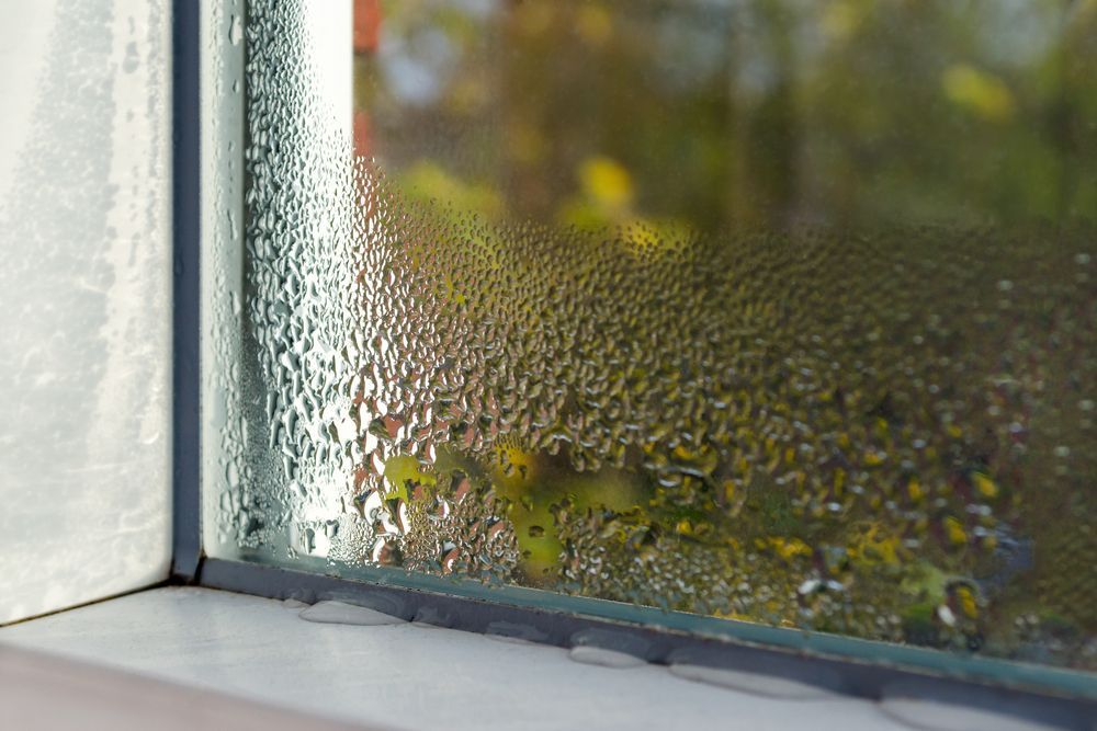 A close up of a window with water drops on it.