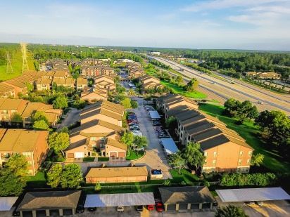 An aerial view of a residential area with a highway in the background.