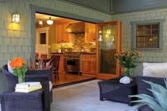 A patio with furniture and a sliding glass door leading to a kitchen.