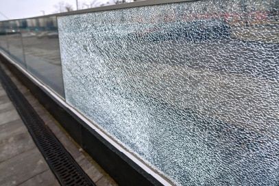 A close up of a broken glass railing on a bridge.