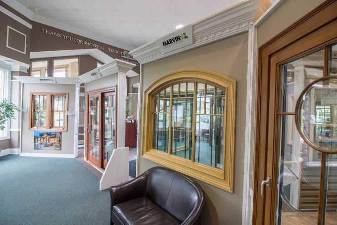 Two men are sitting at a table looking at a laptop computer.