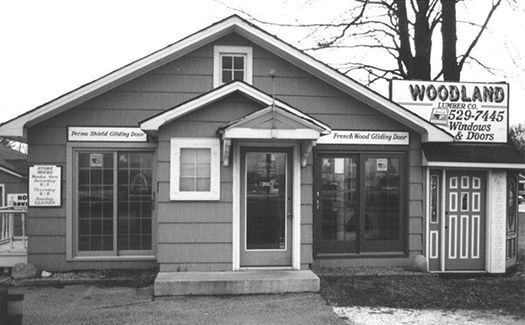 A black and white photo of a woodland building