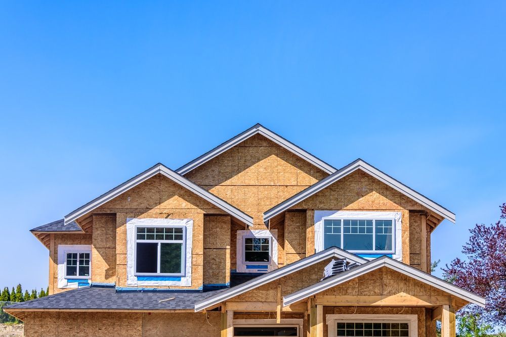 A large house under construction with a blue sky in the background.