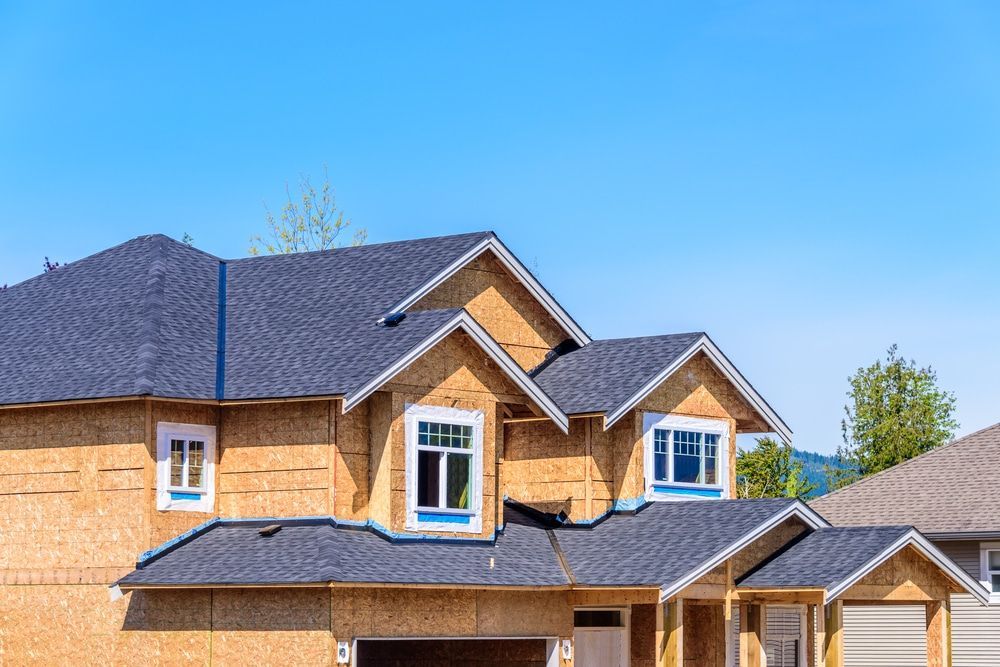 A house under construction with a blue sky in the background.