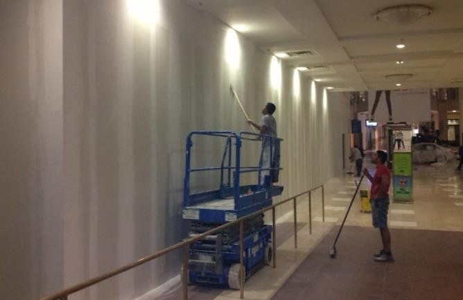 Worker painting and repairing the building