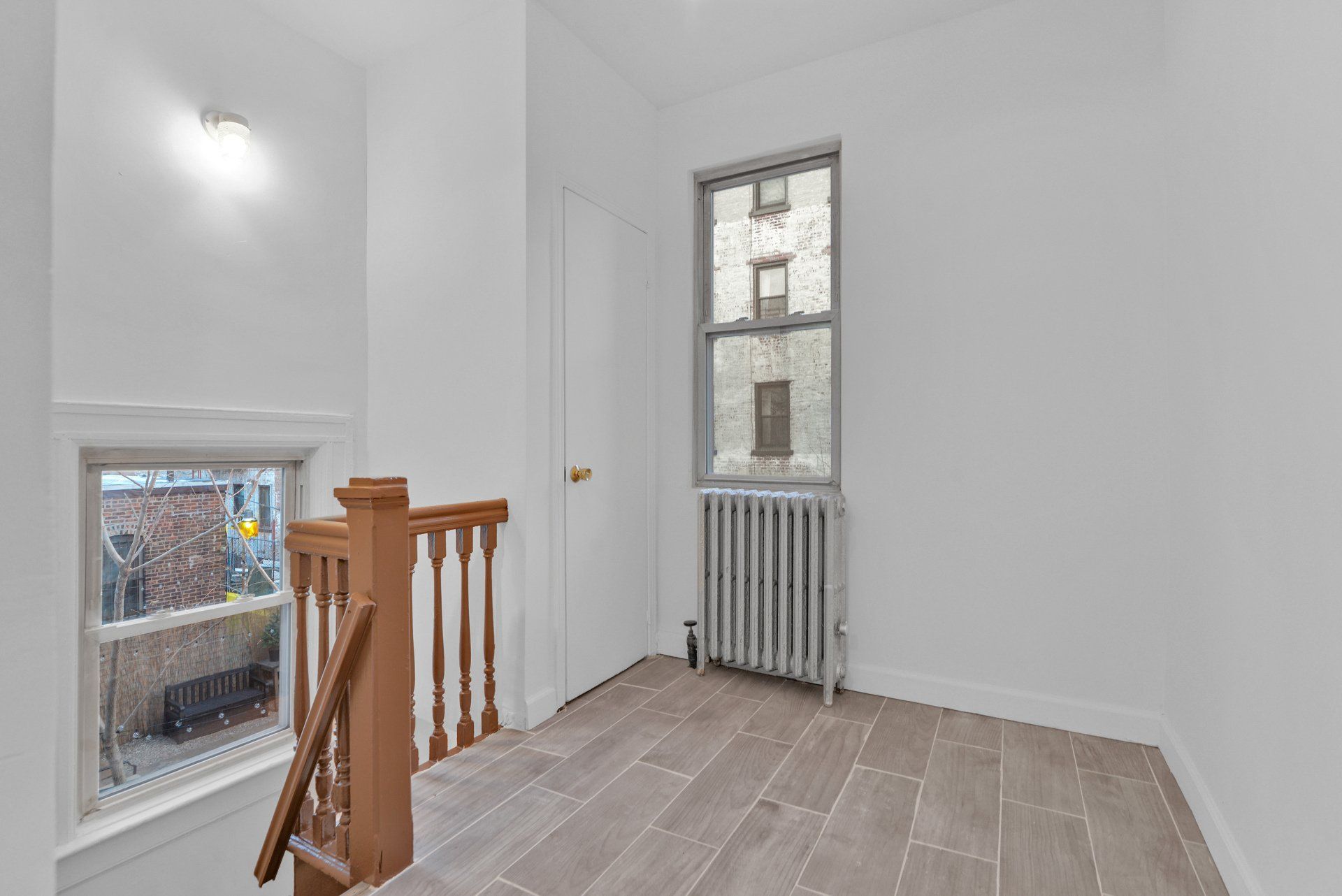 An empty room with a wooden staircase and a radiator.
