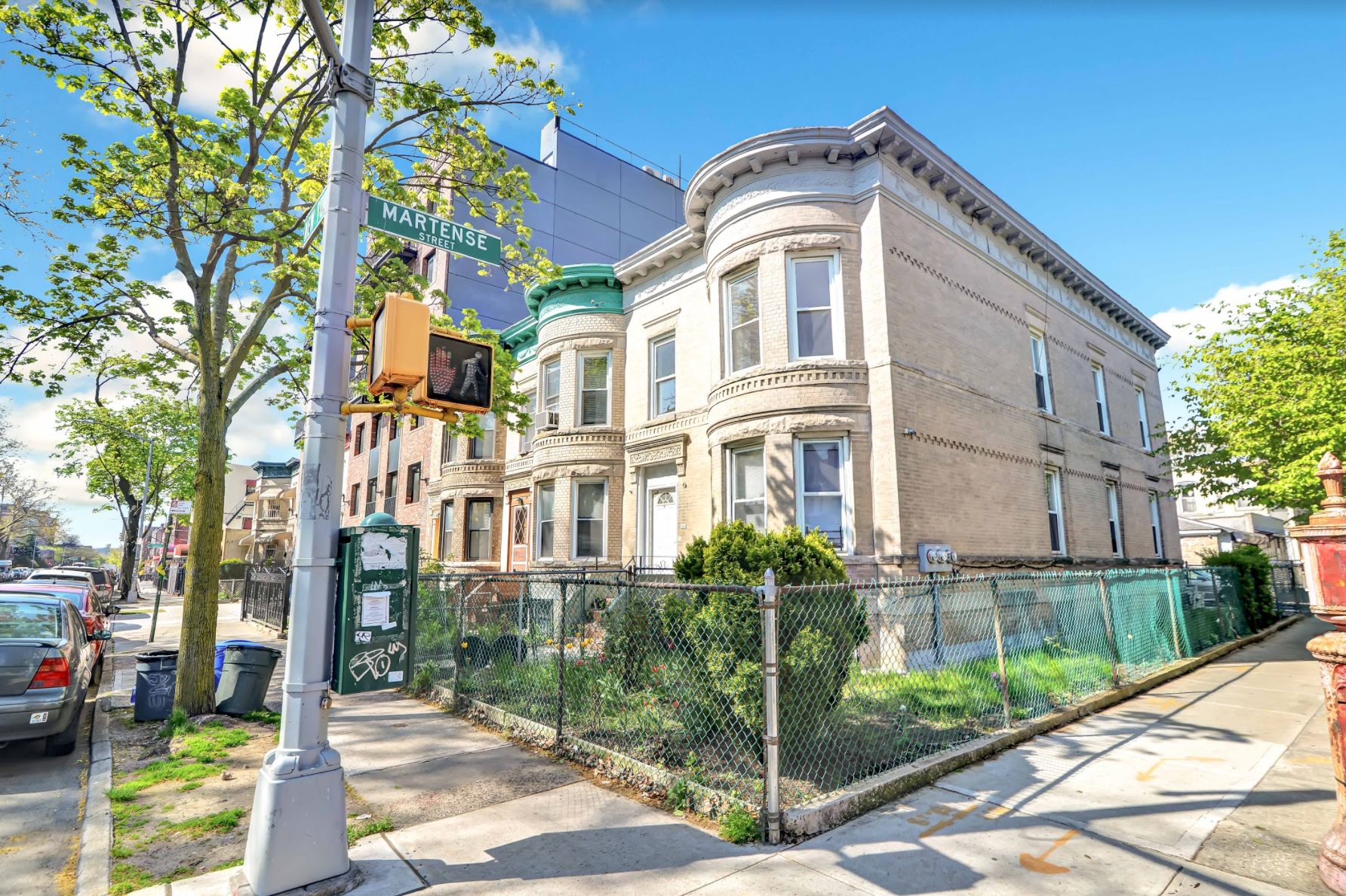 A large brick building is sitting on the corner of a city street.