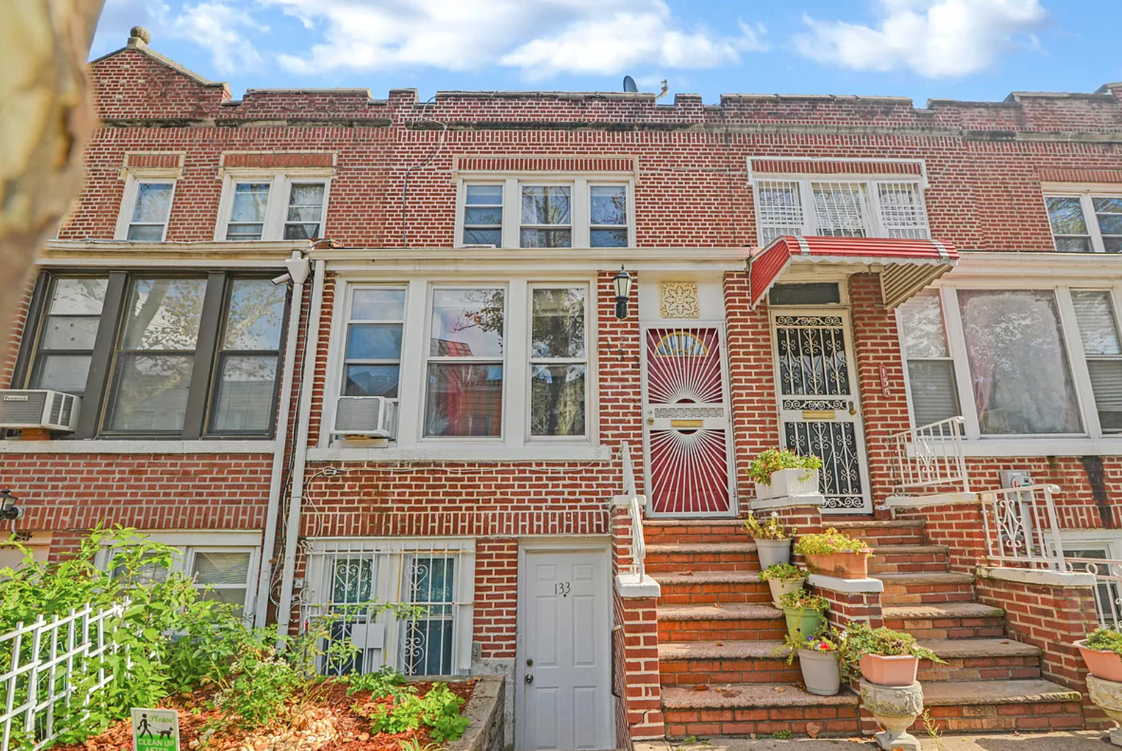 A brick building with stairs leading up to the front door.