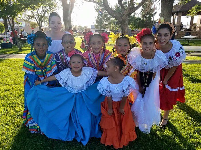 A group of young girls are posing for a picture in a park.