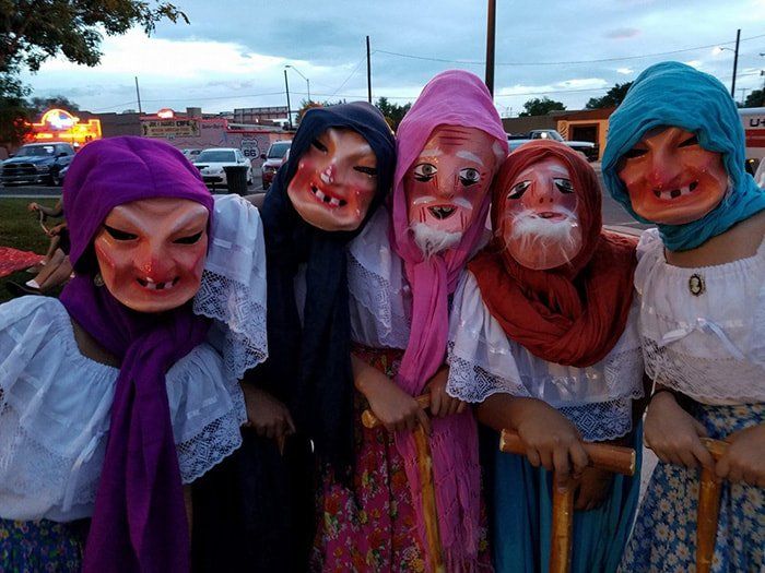 A group of women wearing masks are posing for a picture