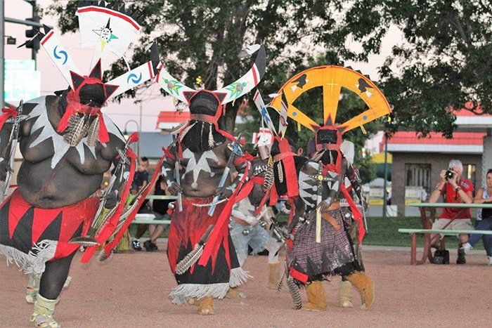 A group of people dressed in native american costumes are dancing
