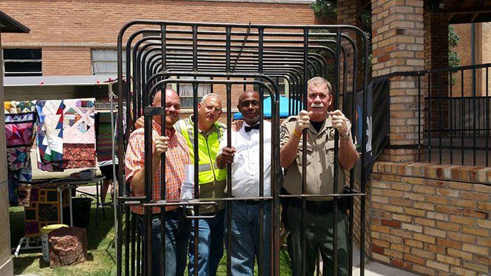 A group of men are standing in front of a cage.