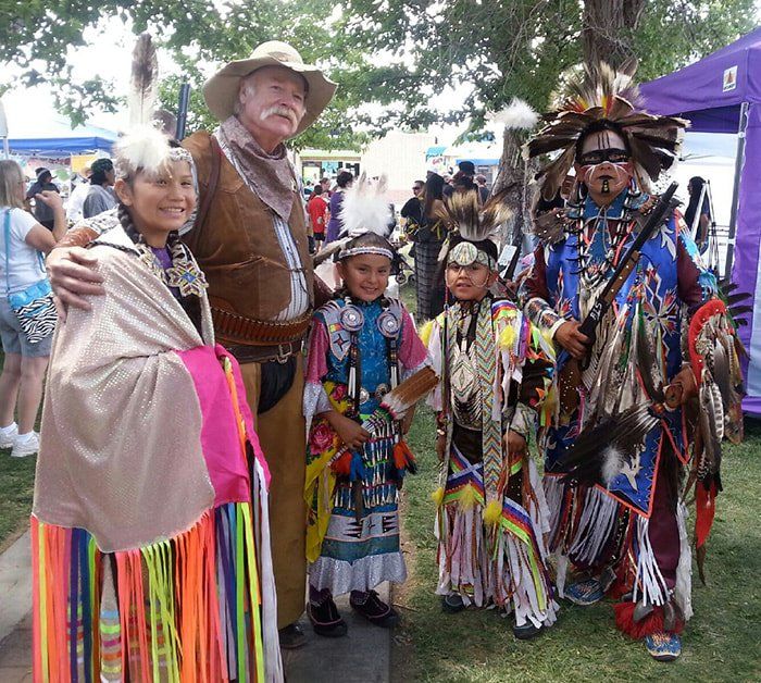 A group of people in native american costumes are posing for a picture