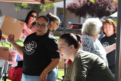 A group of women are standing under a tent.