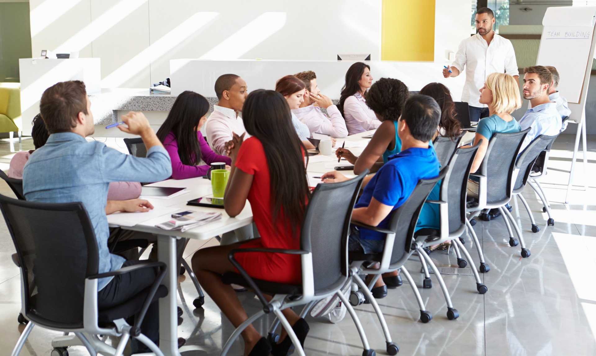 A group of people are sitting around a table having a meeting.