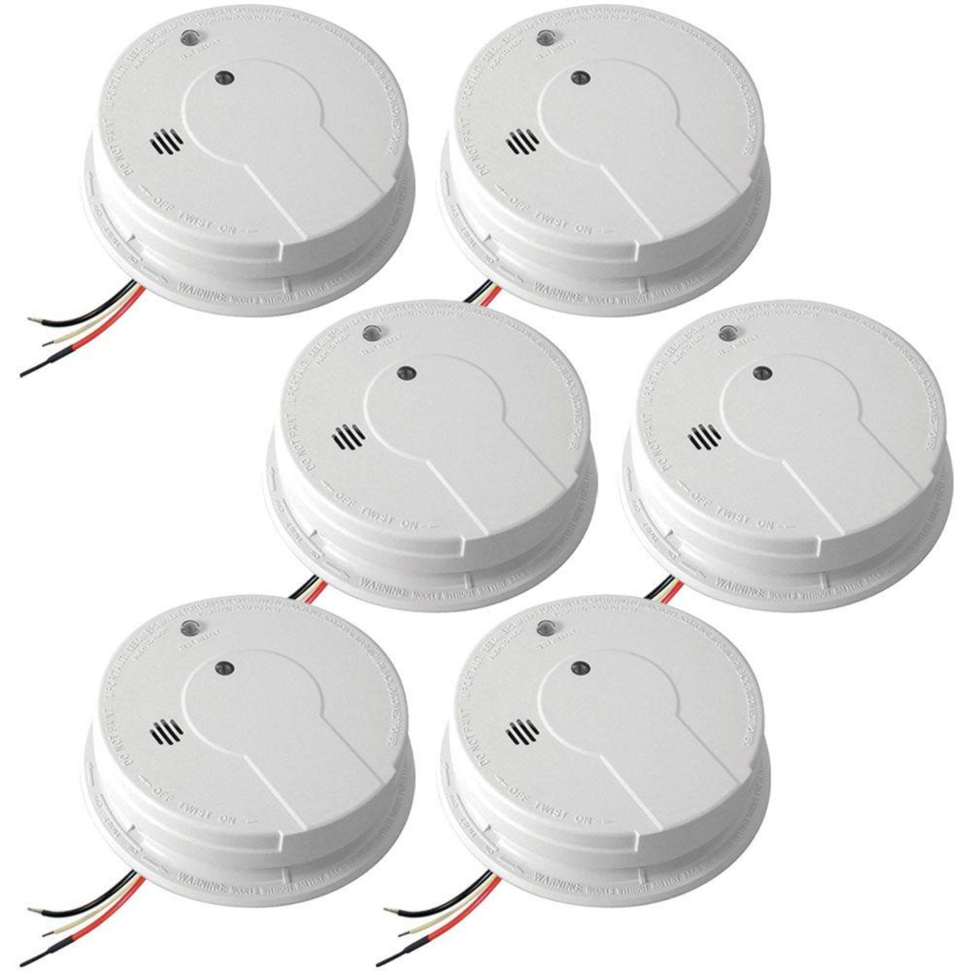 A set of six smoke detectors with wires attached to them