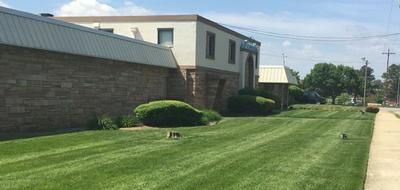 Exterior of a building with well-manicured lawn and a sidewalk.