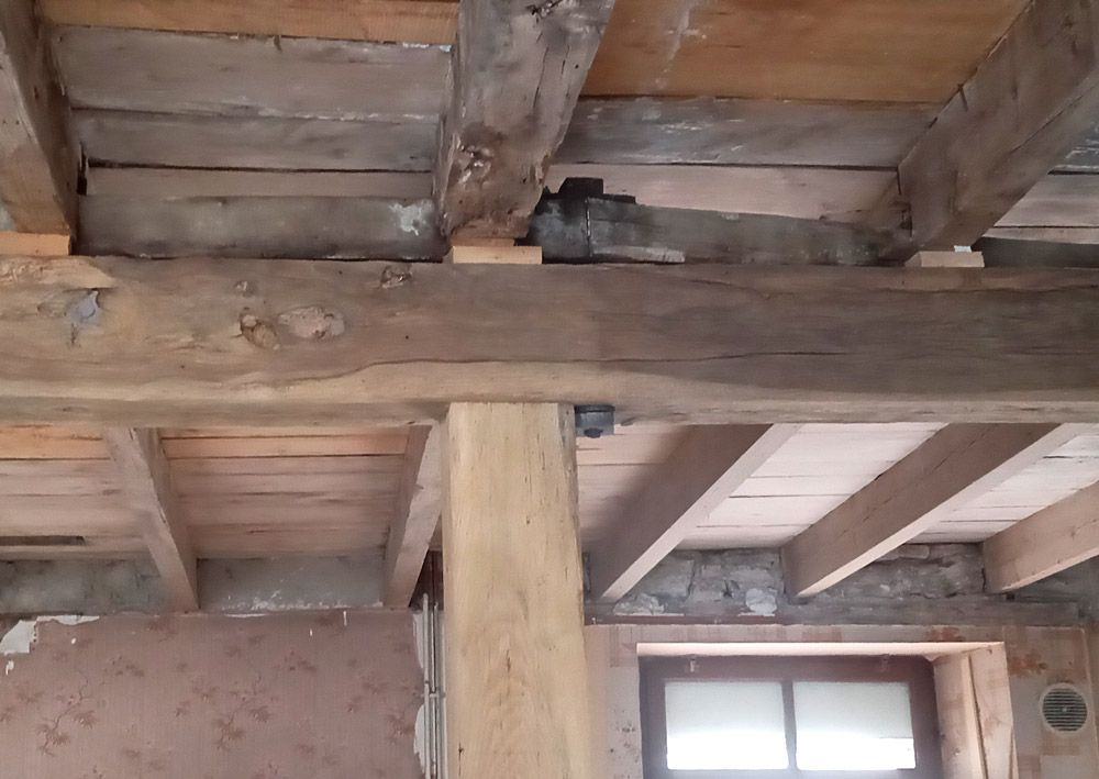 Une pièce avec des poutres en bois et une fenêtre