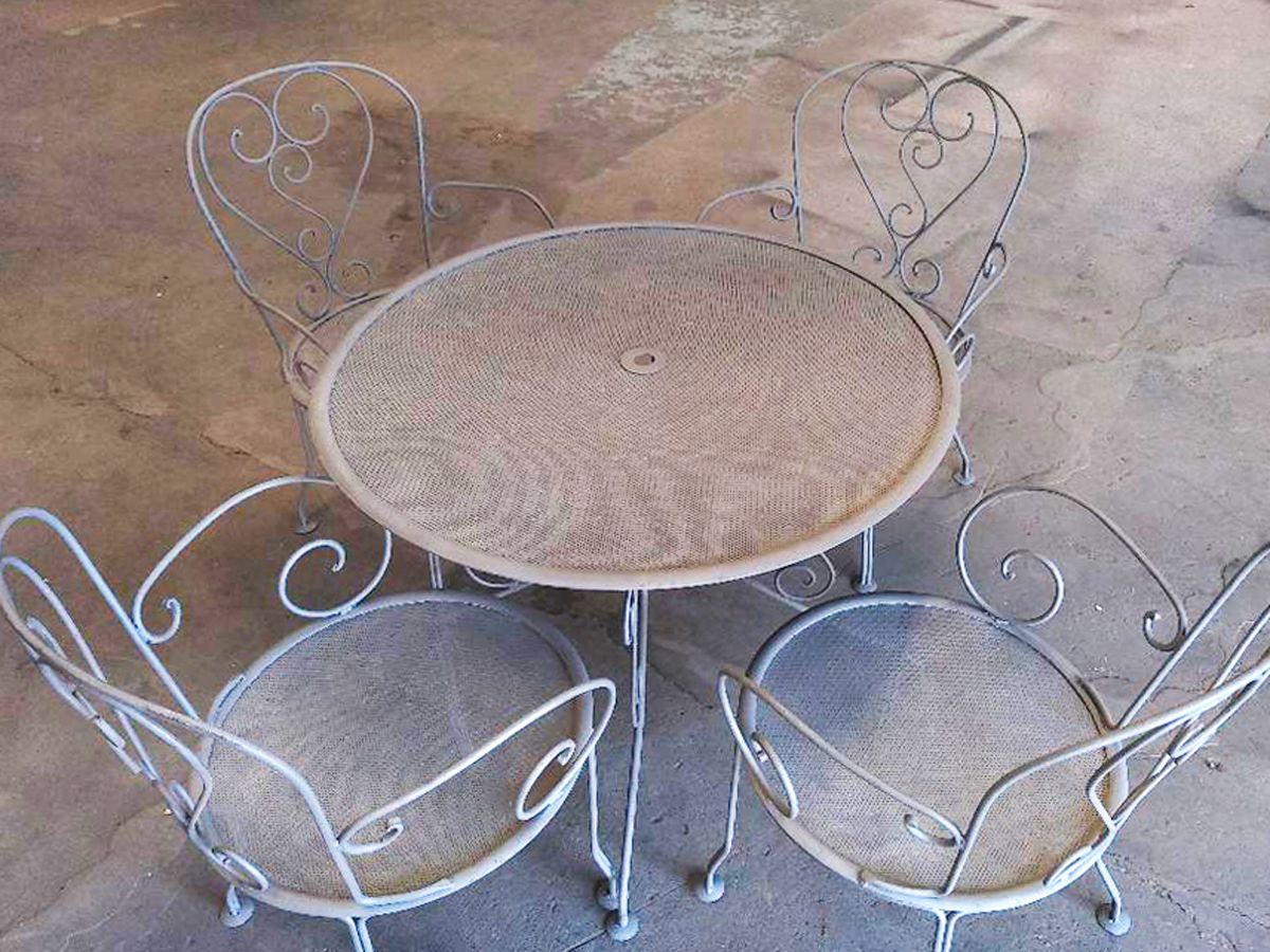 Une table et des chaises sont posées sur un sol en béton